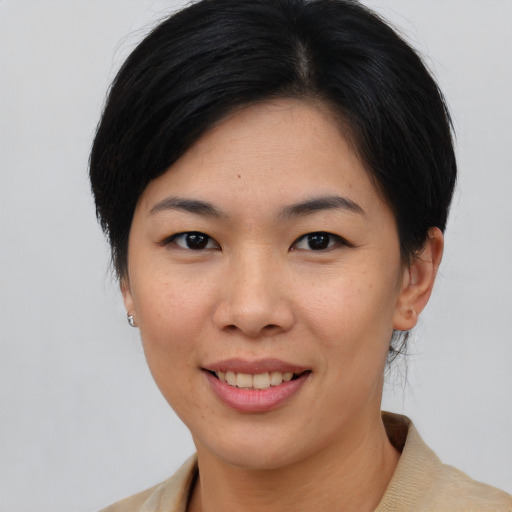 Joyful asian young-adult female with short  brown hair and brown eyes