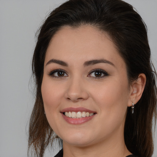 Joyful white young-adult female with long  brown hair and brown eyes