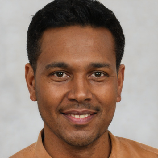 Joyful black young-adult male with short  black hair and brown eyes