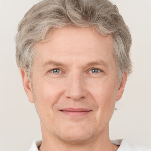 Joyful white adult male with short  blond hair and grey eyes