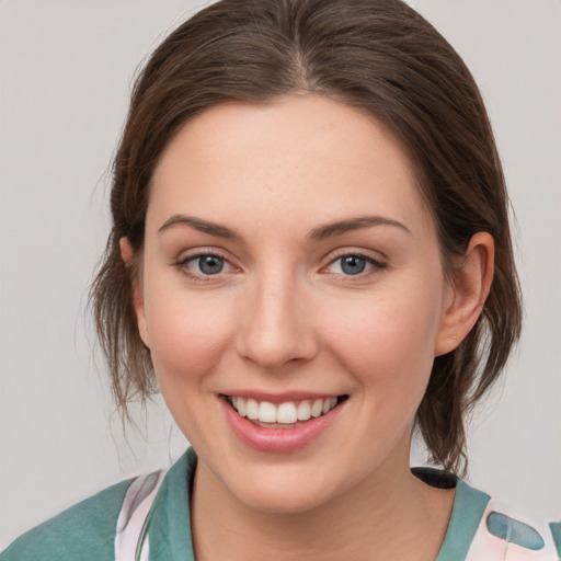 Joyful white young-adult female with medium  brown hair and grey eyes