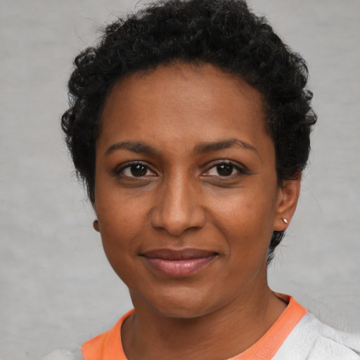 Joyful black adult female with short  black hair and brown eyes