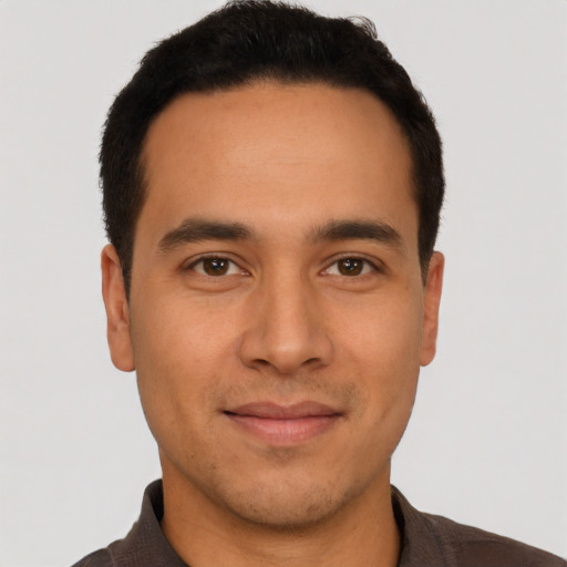 Joyful latino young-adult male with short  brown hair and brown eyes