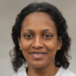 Joyful latino adult female with medium  brown hair and brown eyes