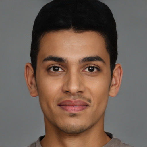 Joyful latino young-adult male with short  brown hair and brown eyes