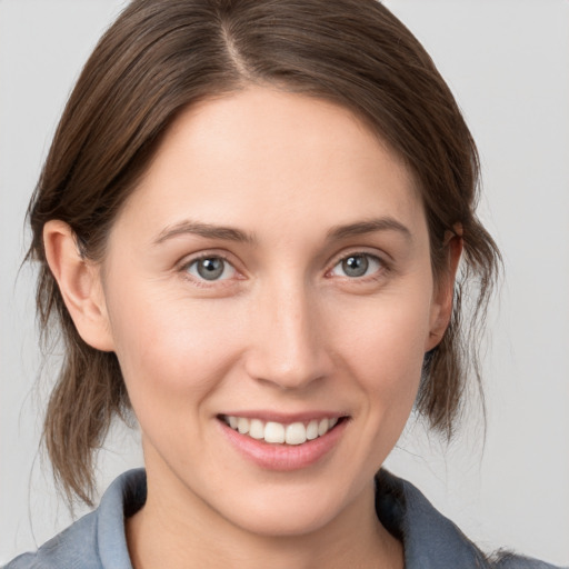 Joyful white young-adult female with medium  brown hair and grey eyes