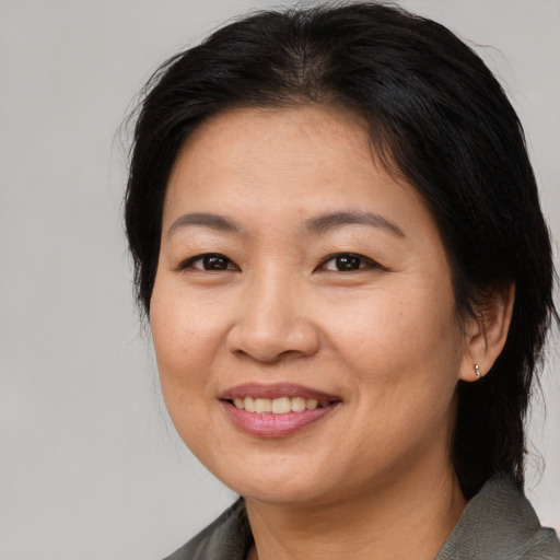 Joyful asian adult female with medium  brown hair and brown eyes