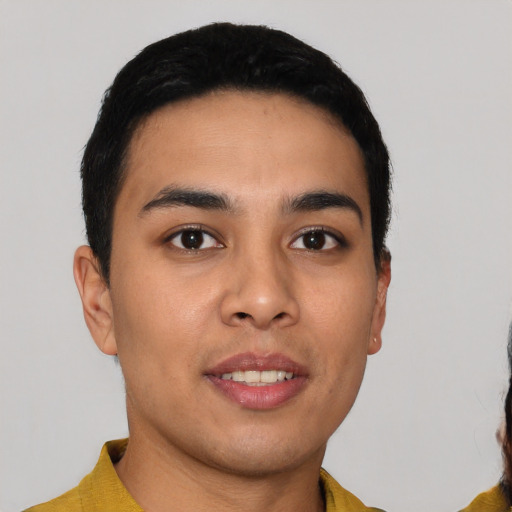 Joyful latino young-adult male with short  black hair and brown eyes