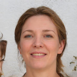 Joyful white young-adult female with medium  brown hair and blue eyes