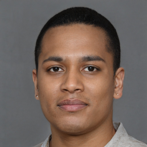 Joyful latino young-adult male with short  brown hair and brown eyes