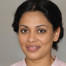 Joyful black young-adult female with medium  brown hair and brown eyes