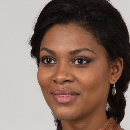 Joyful black young-adult female with long  brown hair and brown eyes