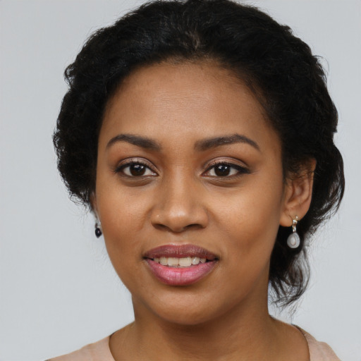 Joyful black young-adult female with long  black hair and brown eyes