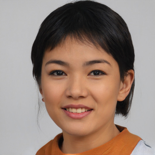 Joyful asian young-adult female with medium  black hair and brown eyes