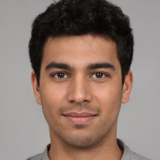 Joyful white young-adult male with short  black hair and brown eyes