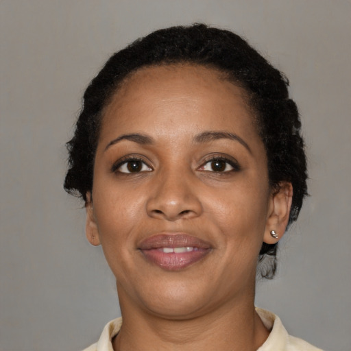Joyful black young-adult female with short  black hair and brown eyes