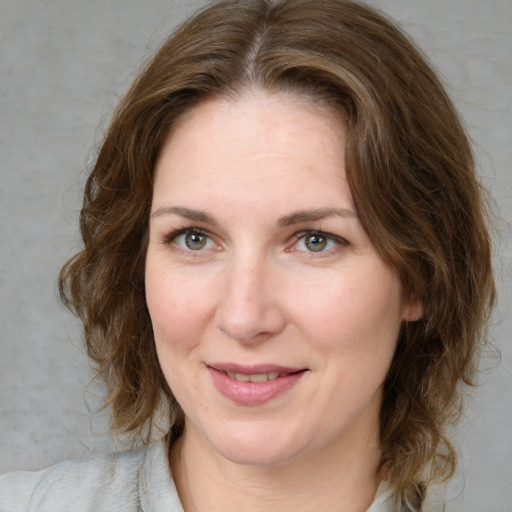 Joyful white adult female with medium  brown hair and green eyes