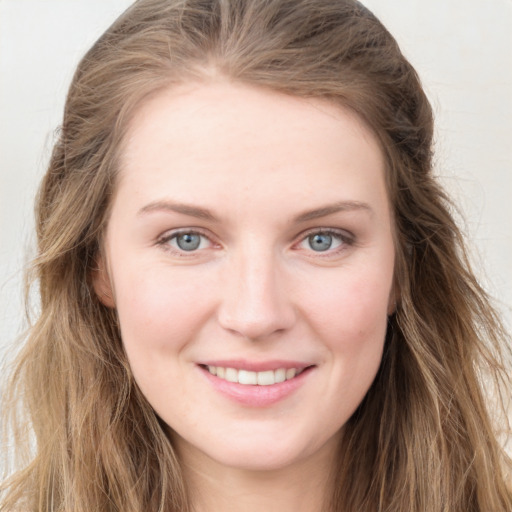 Joyful white young-adult female with long  brown hair and blue eyes