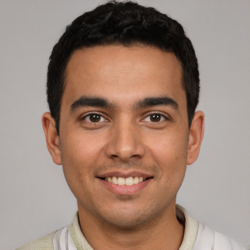 Joyful latino young-adult male with short  black hair and brown eyes