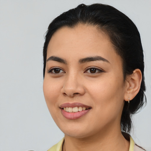 Joyful latino young-adult female with long  black hair and brown eyes