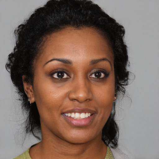 Joyful black young-adult female with short  brown hair and brown eyes