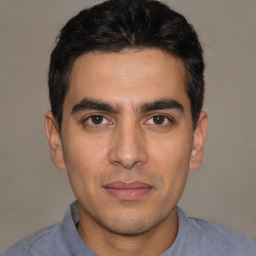 Joyful white young-adult male with short  black hair and brown eyes