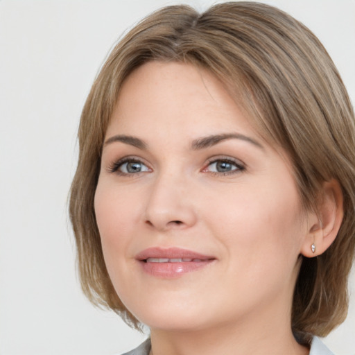 Joyful white young-adult female with medium  brown hair and grey eyes