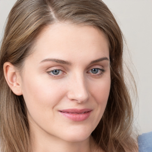 Joyful white young-adult female with long  brown hair and blue eyes