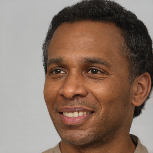 Joyful black adult male with short  brown hair and brown eyes