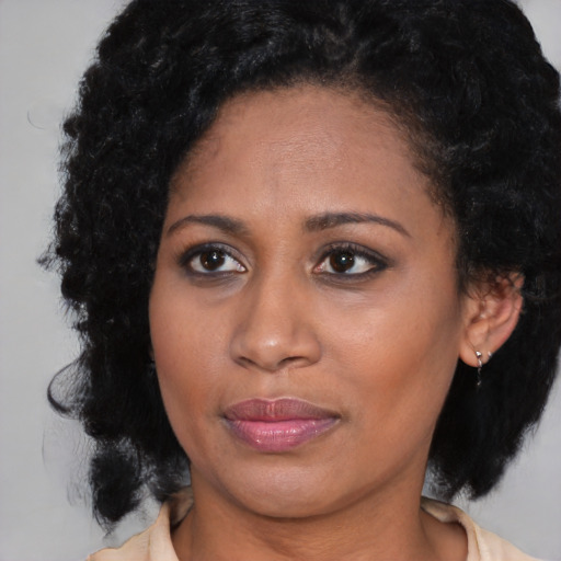 Joyful black young-adult female with medium  brown hair and brown eyes