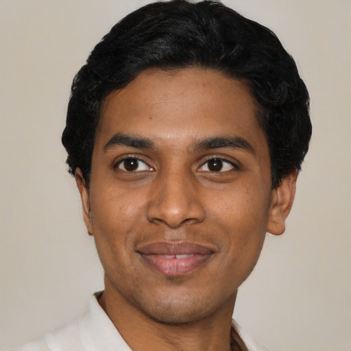 Joyful black young-adult male with short  black hair and brown eyes