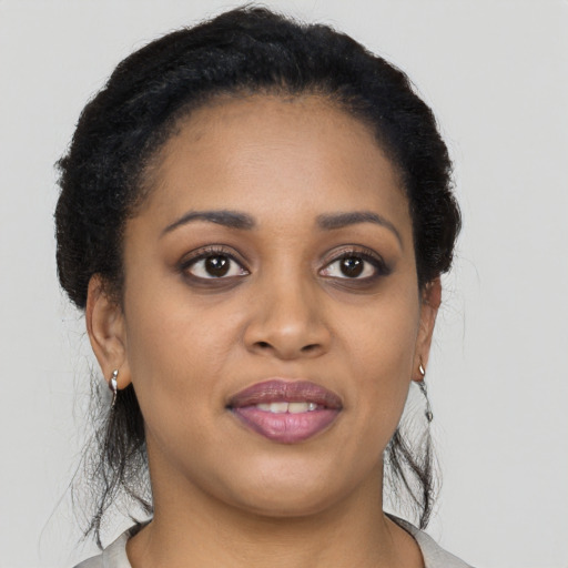 Joyful black young-adult female with medium  brown hair and brown eyes