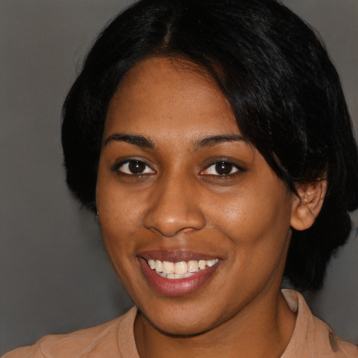 Joyful black young-adult female with medium  black hair and brown eyes