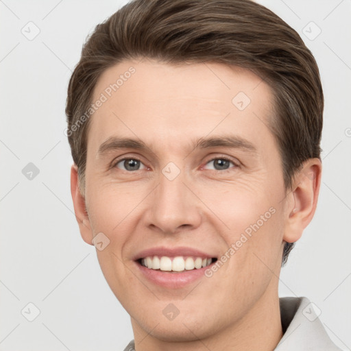 Joyful white young-adult male with short  brown hair and grey eyes