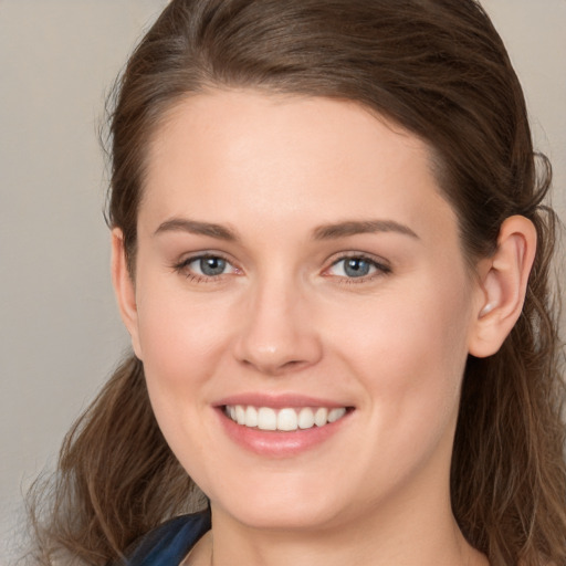 Joyful white young-adult female with long  brown hair and grey eyes