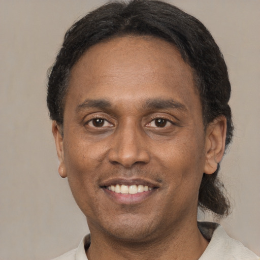 Joyful black adult male with short  brown hair and brown eyes