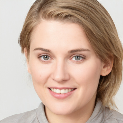 Joyful white young-adult female with medium  brown hair and blue eyes