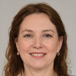 Joyful white adult female with medium  brown hair and green eyes