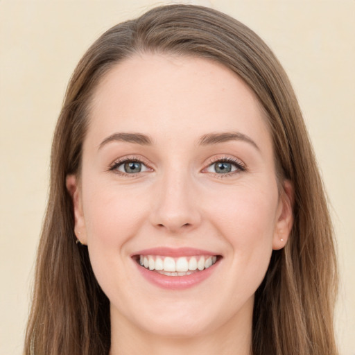 Joyful white young-adult female with long  brown hair and green eyes