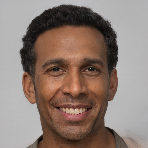 Joyful latino adult male with short  black hair and brown eyes