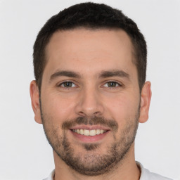 Joyful white young-adult male with short  brown hair and brown eyes