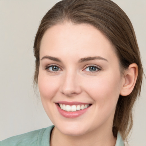 Joyful white young-adult female with medium  brown hair and green eyes