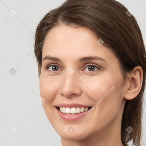 Joyful white young-adult female with long  brown hair and brown eyes