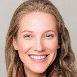 Joyful white adult female with long  brown hair and blue eyes