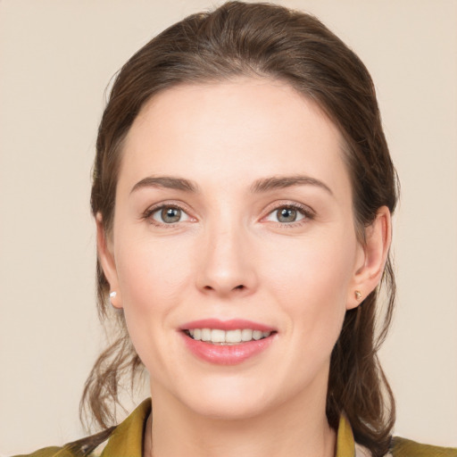 Joyful white young-adult female with medium  brown hair and green eyes