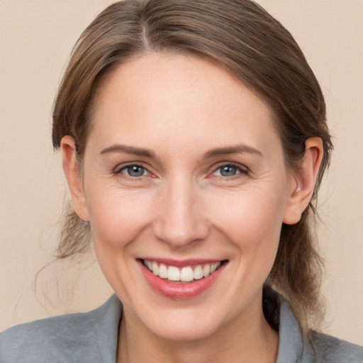 Joyful white young-adult female with medium  brown hair and grey eyes