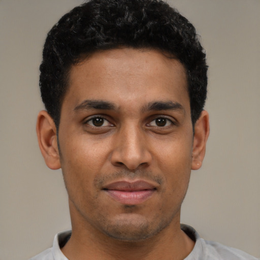 Joyful latino young-adult male with short  brown hair and brown eyes