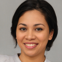 Joyful latino young-adult female with medium  brown hair and brown eyes