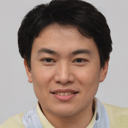 Joyful asian young-adult male with short  brown hair and brown eyes