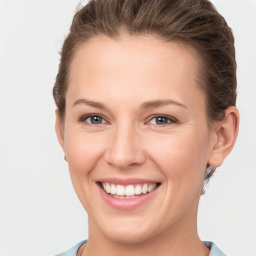 Joyful white young-adult female with short  brown hair and grey eyes